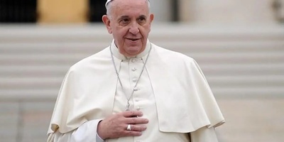 A birthday candle for Pope Francis’ 81st birthday placed on a pizza + photo